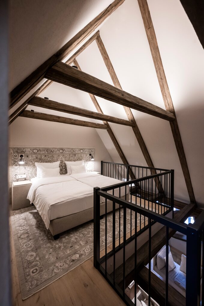 Hotel Golden Rose, projekt noa*. Mimo że to hotel, to podobne zabiegi aranżacyjne możemy również zastosować we wnętrzach domów i poddaszy w kamienicach. Mowa tu przede wszystkim o wyeksponowaniu belek konstrukcyjnych i więźby dachowej.