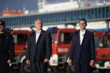 Minister Brudziński i premier Morawiecki witają wracających ze Szwecji strażaków 