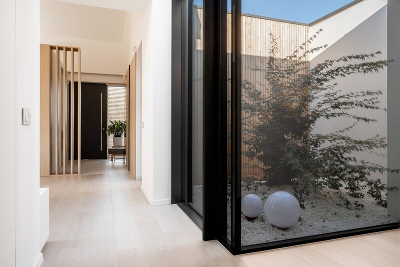 Atrium House, to prywatny azyl, w którym światło zostało podniesione do rangi głównego elementu kompozycyjnego, determinującego zarówno estetykę, jak i funkcjonalność. Projekt: pracownia MOKAA