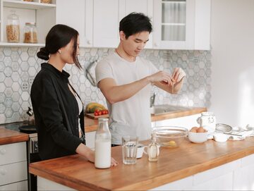 Zdjęcie ilustrujące parę gotującą w kuchni
