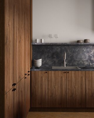 Rustykalna w wyrazie zabudowa (Dąb Carpenter Coffee) w zestawieniu z blatem i panelem ściennym w stalowym dekorze (Dark Steel) zyskuje loftowy sznyt