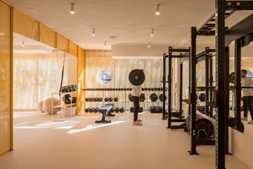 Wnętrza klubu fitness autorstwa Canobardin wyróżniają ażurowe przegrody z perforowanej stali i konsekwentnie zastosowana paleta kolorów 