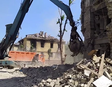 Miniatura: Mariupol. Rosjanie koparkami zbierają...