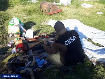 Arsenał przejęty przez CBŚP Funkcjonariusz CBŚP bada przejęty arsenał