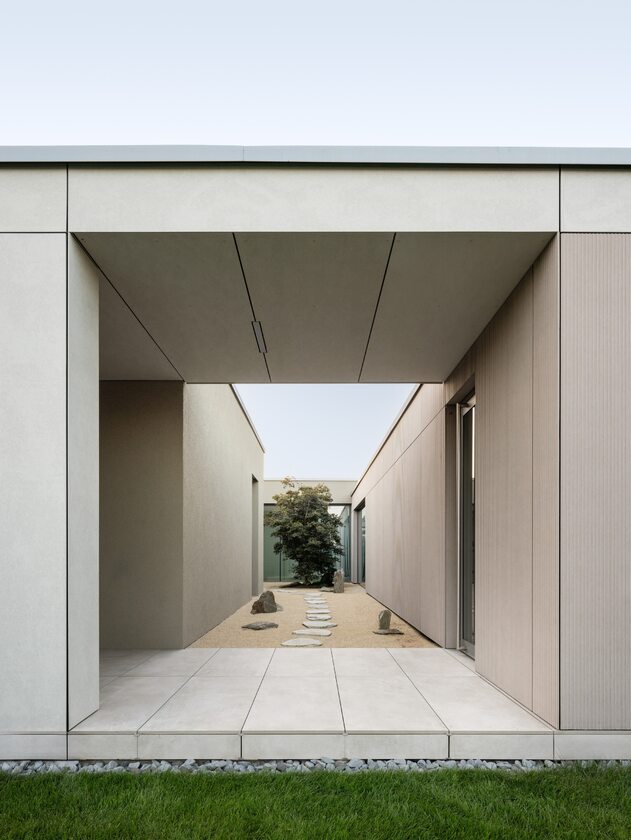 Dom z patio i roletami zasłaniającymi tarasy – prywatność na małej działce, projekt Beef Architekti 