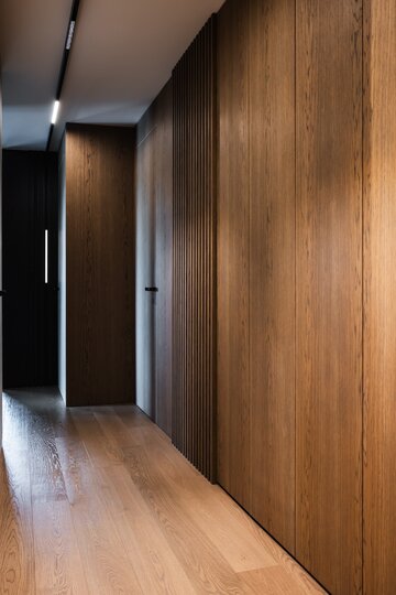 Projekt pracowni masz.design pokazuje, że ciemna kolorystyka, naturalne drewno i światło mogą stworzyć wnętrze pełne spokoju, elegancji i ponadczasowego charakteru 