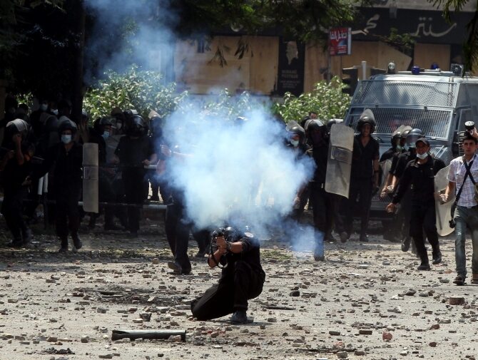 Egipski oficer wystrzeliwuje gaz łzawiący w stronę protestujących w pobliżu ambsady USA w Kairze (fot. PAP/EPA/KHALED ELFIQI)