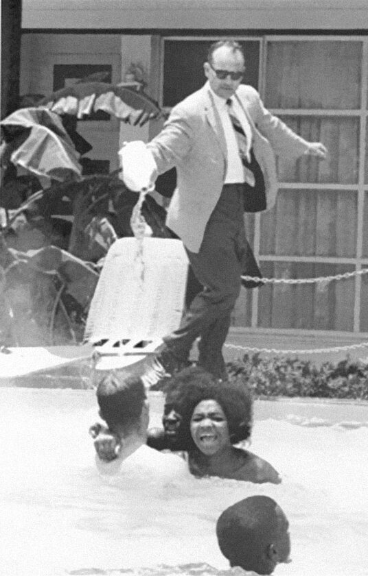 Właściciel hotelu wlewa kwas do basenu, podczas gdy pływają w nim czarnoskórzy ludzie, 1964 (fot. boredpanda.com)