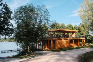 Kalbornia Mazury nad jeziorem Dąbrowa Wielka. Całoroczne domy zaprojektowane przez Boris Kudlička with Partners otwierają się na wodę i otaczający las 