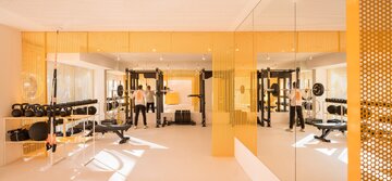 Wnętrza klubu fitness autorstwa Canobardin wyróżniają ażurowe przegrody z perforowanej stali i konsekwentnie zastosowana paleta kolorów 
