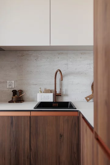 Ciepła kolorystyka, zabudowy na wymiar i inspiracje stylem mid-century modern tworzą wnętrze, które łączy ponadczasową estetykę z codzienną funkcjonalnością 