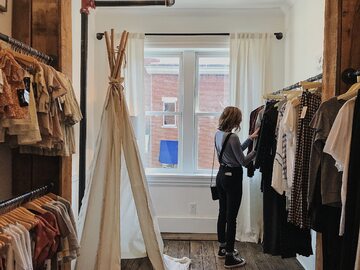 Kobieta wybiera ubrania w sklepie odzieżowym