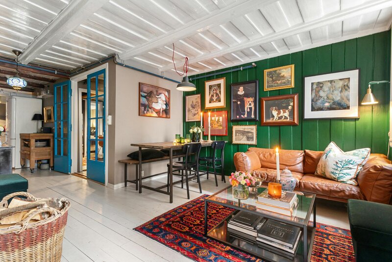 Zielona boazeria, galeria obraz&oacute;w i&nbsp;ciepłe światło &ndash; przykład, jak jeden odważny kolor potrafi całkowicie odmienić salon bez efektu przesady