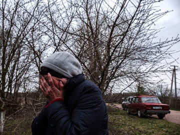 10 kwietnia, mieszkanka Lipówki płacze, gdy policja zabiera ciało jej zmarłego syna