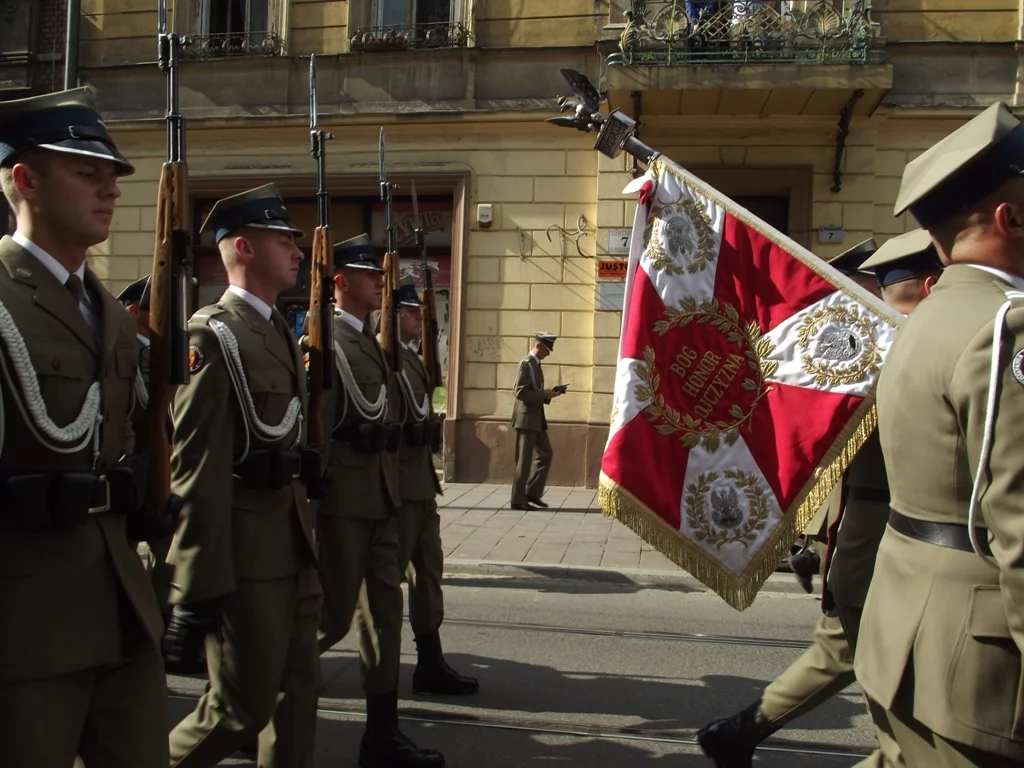 Żołnierze ze sztandarem. Na nim hasło "Bóg, Honor, Ojczyzna"