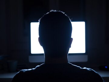 Anonimowy mężczyzna przed ekranem komputera
