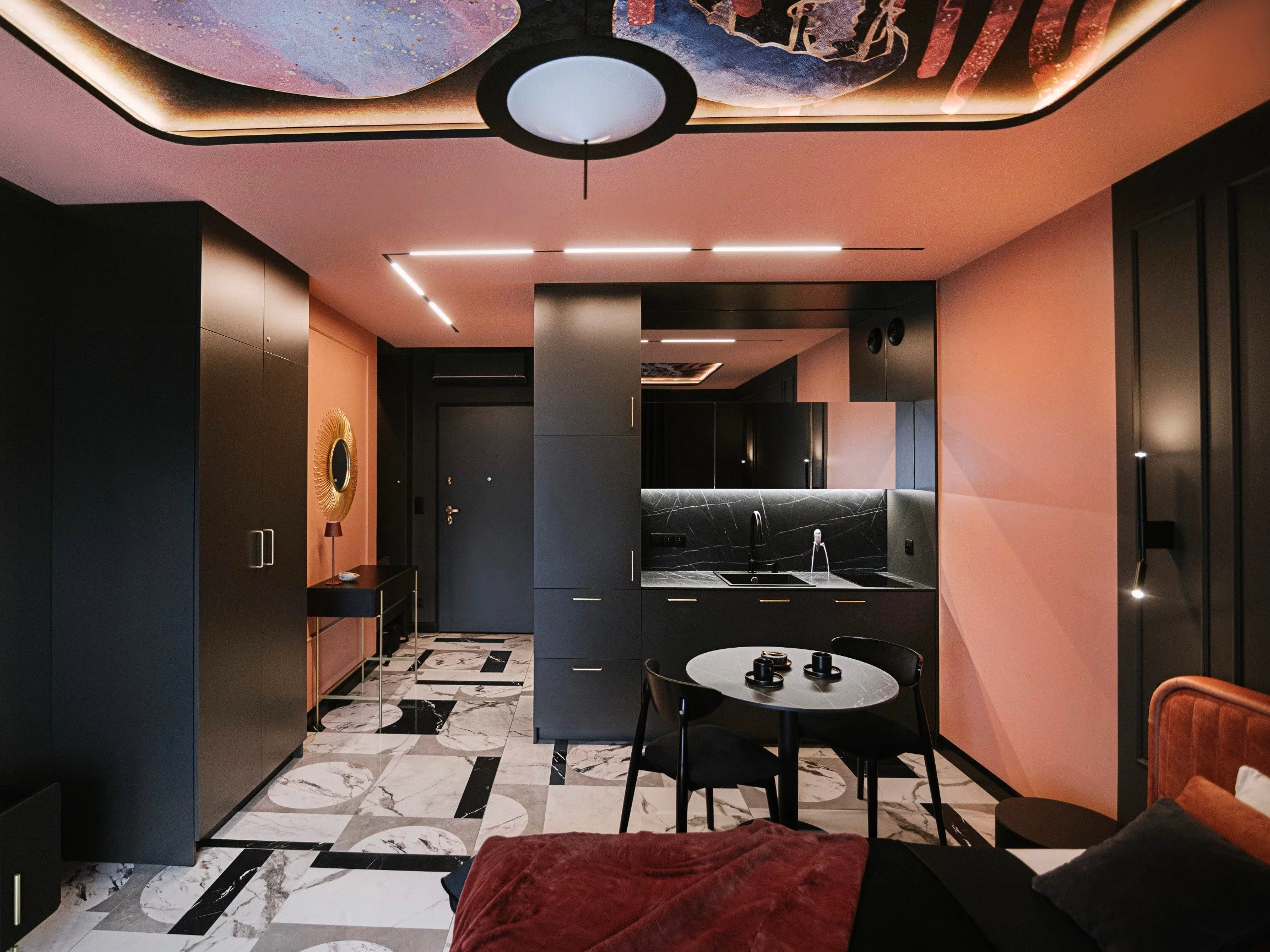 40-metrowy apartament we Wrocławiu zaprojektowany przez pracownię Artefekt łączy głęboką czerń, łososiowy róż i złote detale z klasyczną sztukaterią