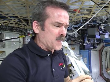 Astronauta Chris Hadfield pijący wodę