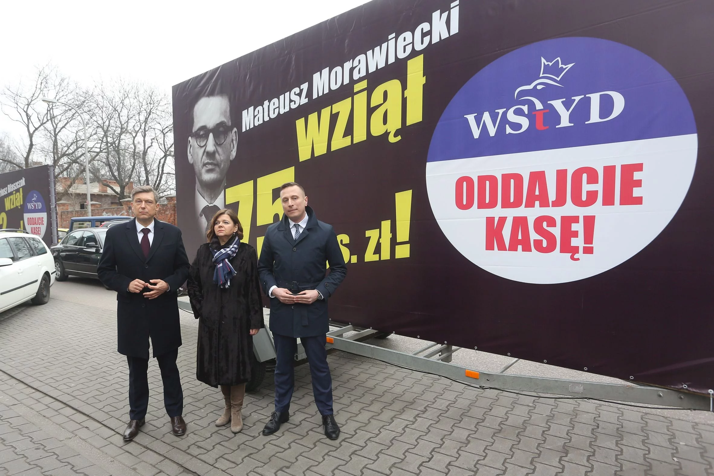 Krzytof Brejza przed billboardem