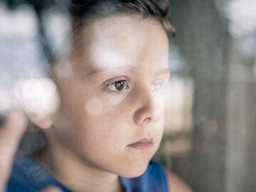 Chłopiec wyglądający przez okno