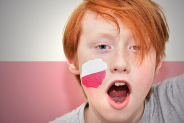 Chłopiec z polską flagą na twarzy