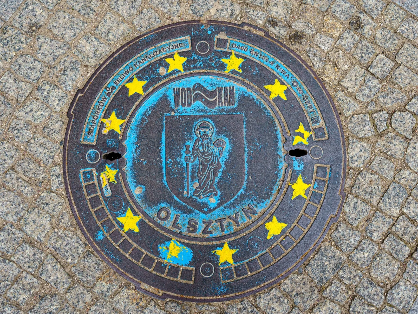 Pokrywa studzienki kanalizacyjnej z herbem Olsztyna, zdjęcie ilustracyjne