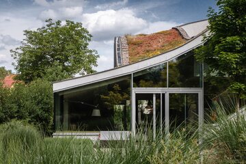 Dom z trawą na dachu i falującymi ścianami, projekt Szymon Rozwałka