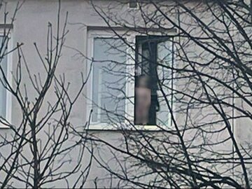 Dziecko stało na parapecie przy otwartym oknie
