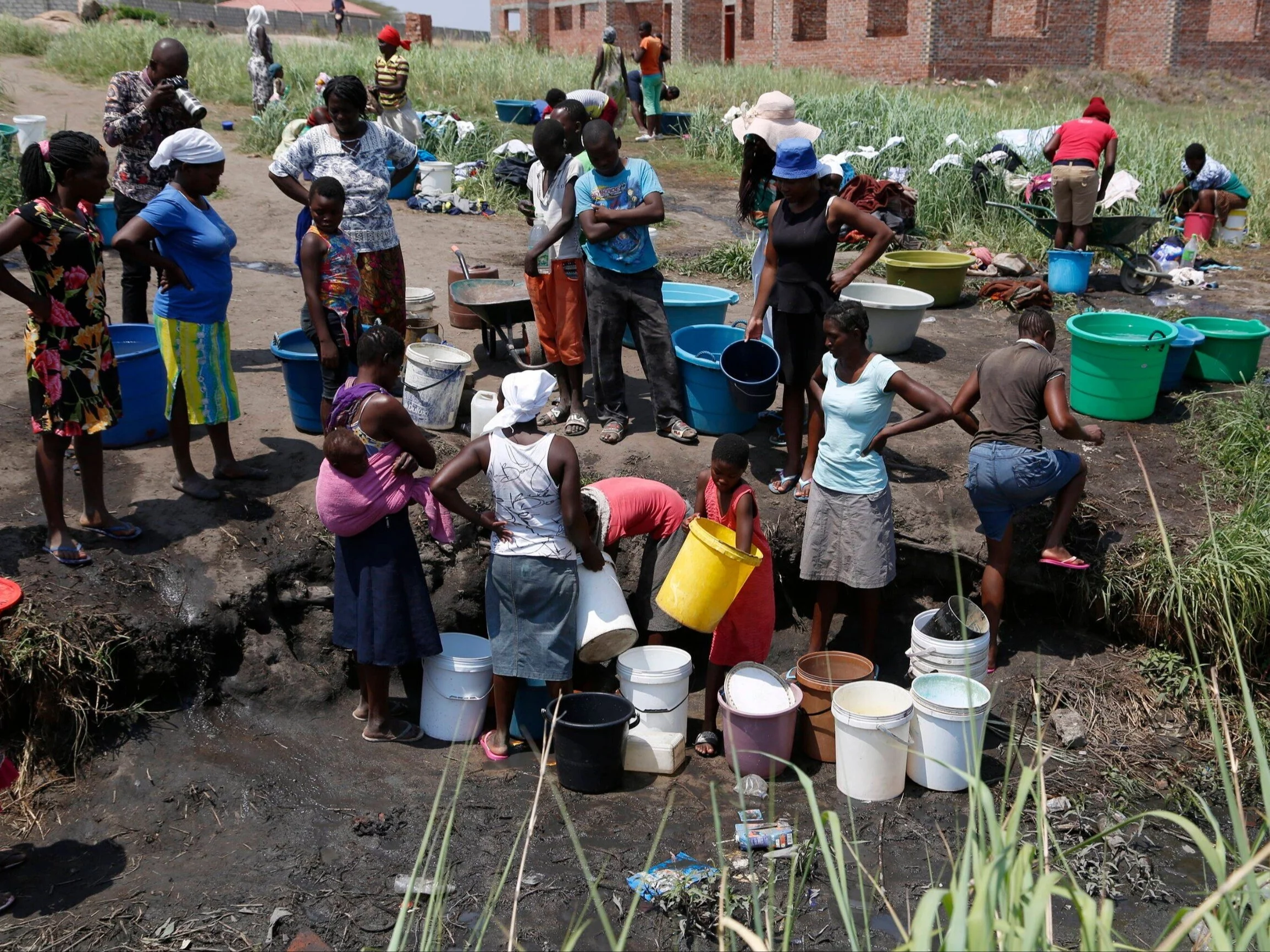 Mieszkańcy czerpiący wodę z niebezpiecznego źródła w Zimbabwe, 2020 r.