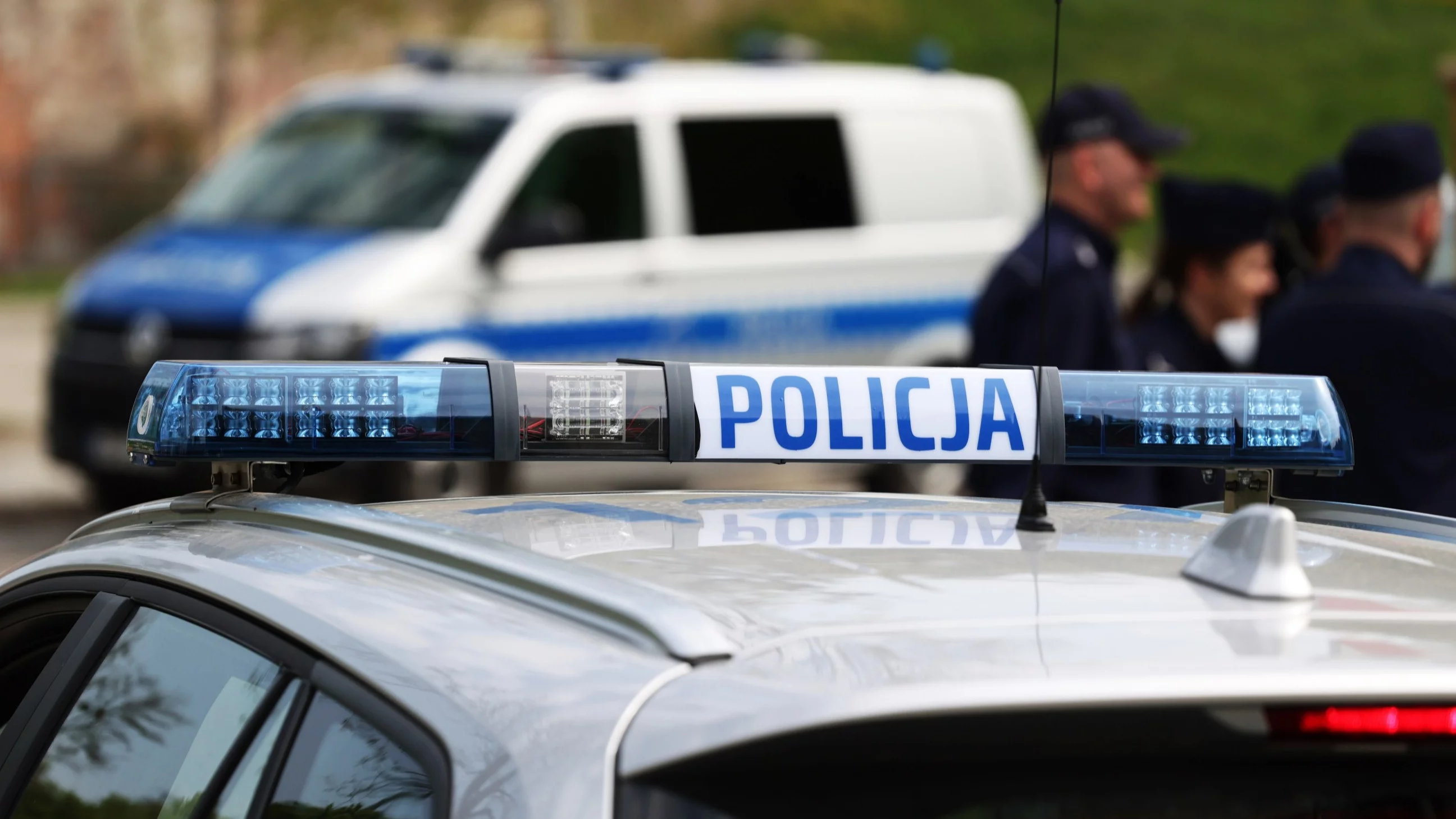 Radiowozy i funkcjonariusze policji, zdjęcie ilustracyjne