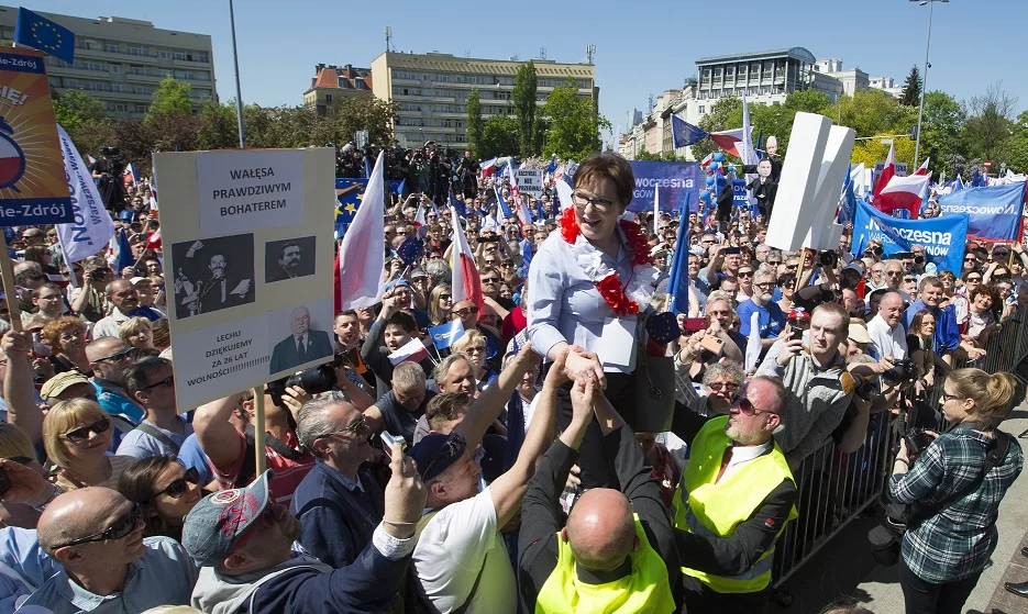 Uczestnicy marszu KOD wnoszą Ewę Kopacz na scenę