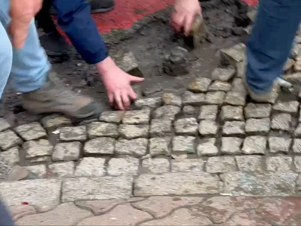 Protestujący wyrywający kostkę brukową, zdjęcie ilustracyjne