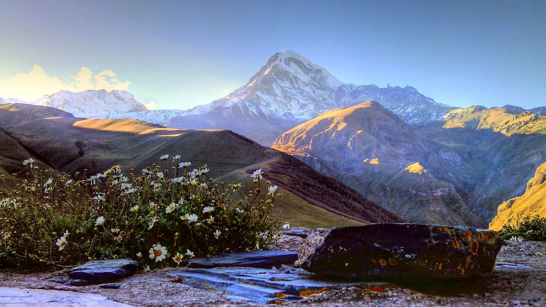 Pasmo górskie na granicy Gruzji i Rosji. Pośrodku widoczny Kazbek, jeden z najwyższych szczytów Kaukazu.