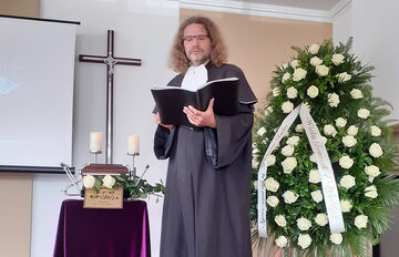Jacek Borowik, mistrz ceremonii pogrzebowych przy urnie z prochami zmarłego