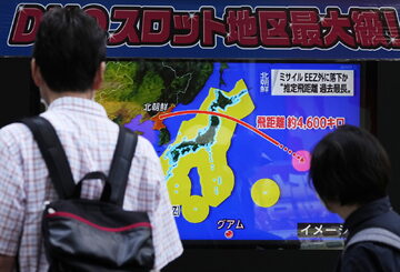 Japończycy obserwujący informacje o wystrzeleniu rakiety nad ich krajem