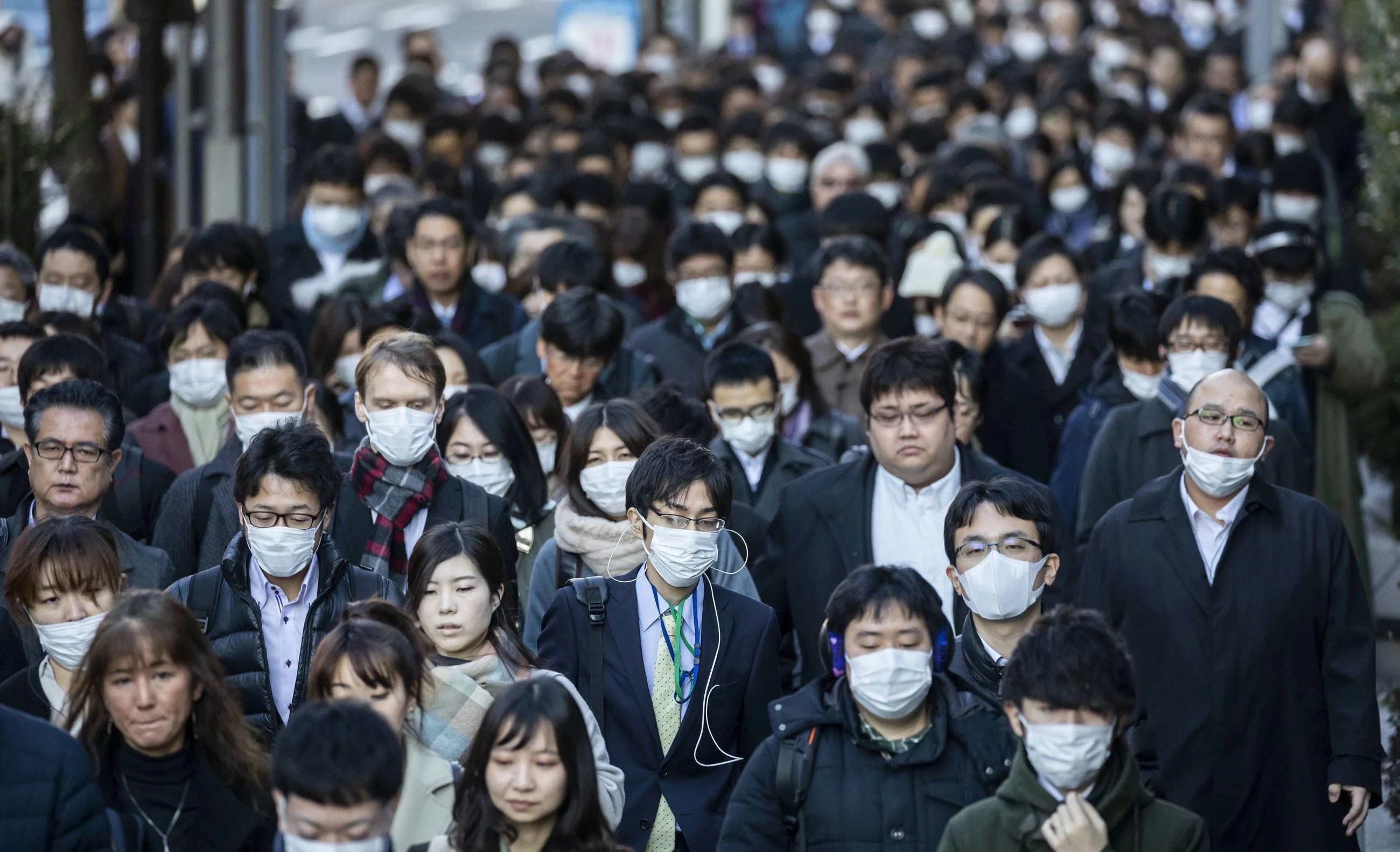 Japończycy na ulicy Tokio w maskach