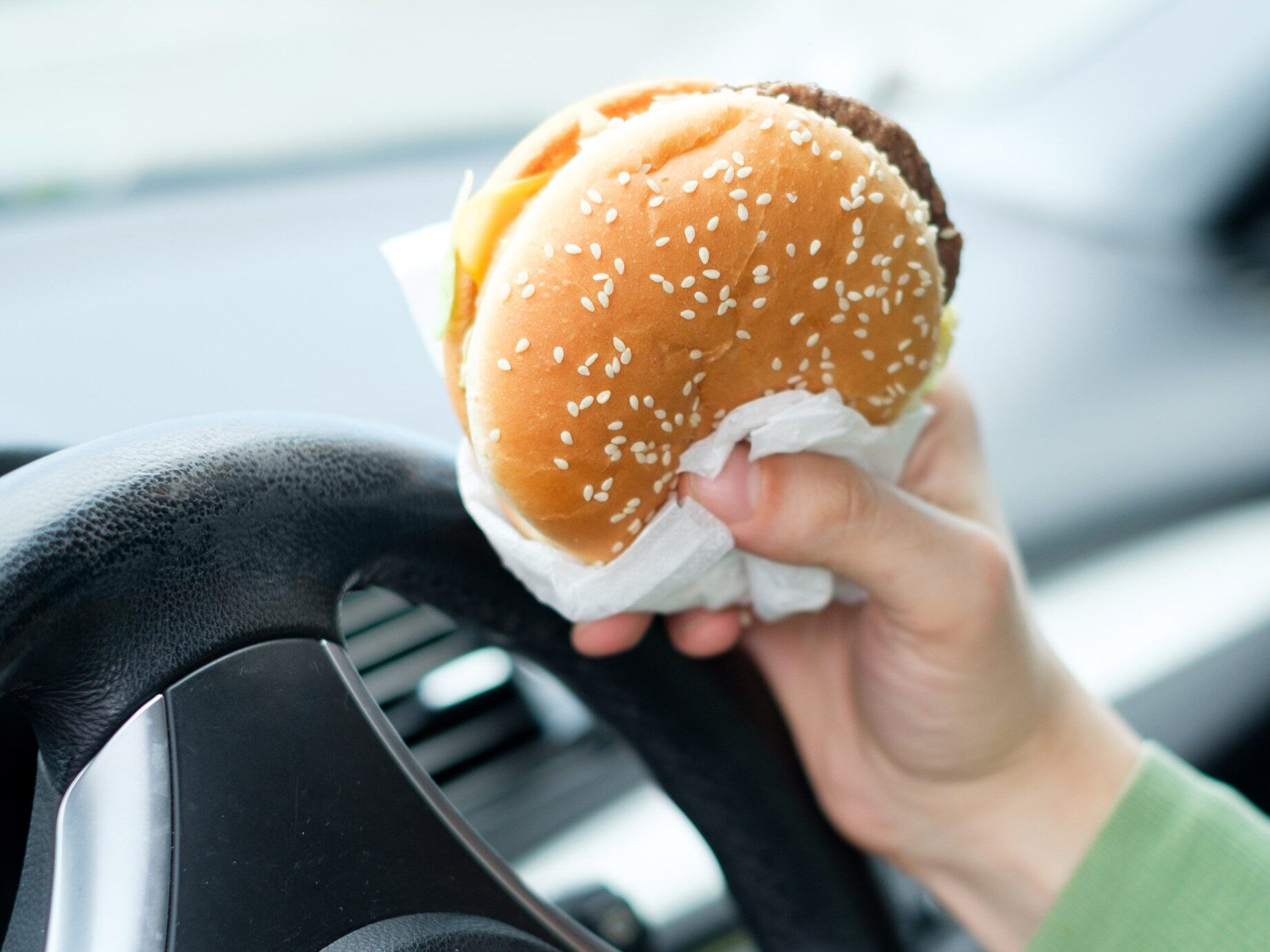 Jedzenie burgera w samochodzie