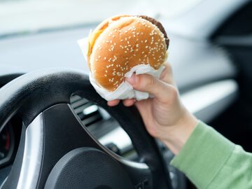 Jedzenie burgera w samochodzie