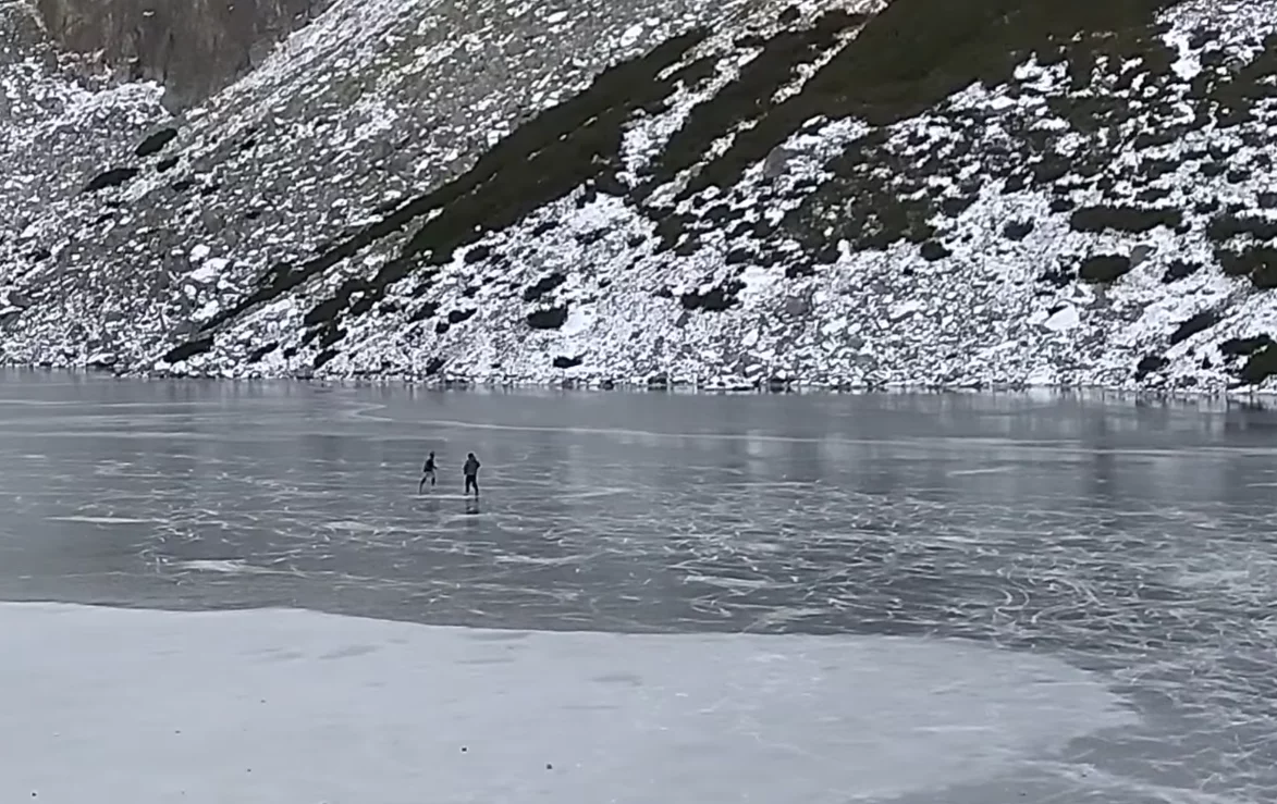 Turyści jeżdżący na łyżwach po Czarnym Stawie Gąsienicowym