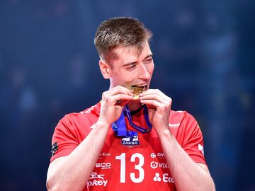 Kamil Semeniuk gryzie medal za wygraną ZAKSY w Lidze Mistrzów