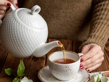 Kobieta nalewa herbatę do filiżanki