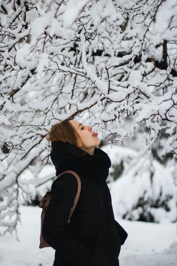 Kobieta usiłująca polizać śnieg