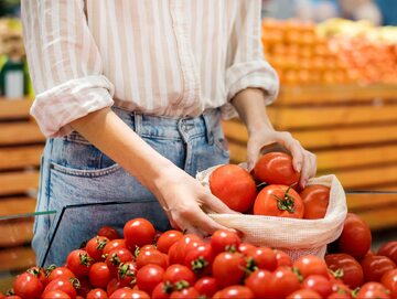 Kobieta wybiera w sklepie pomidory