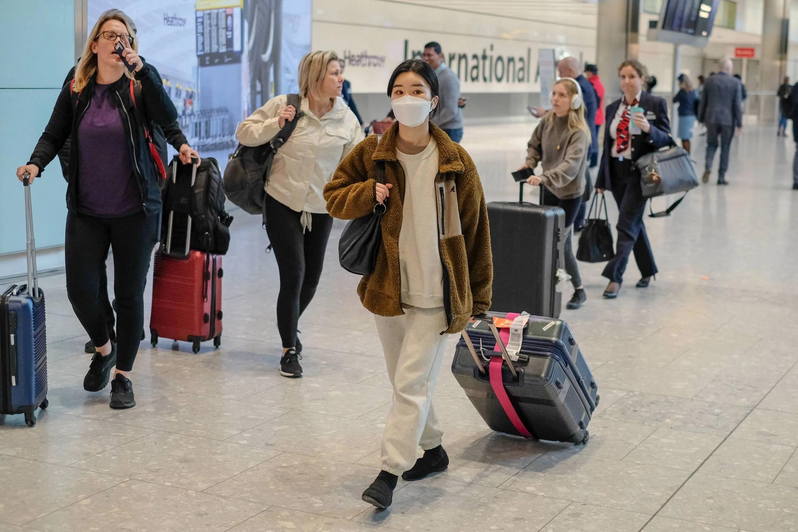 Podróżna w masce medycznej na lotnisku Heathrow