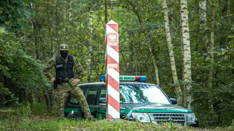 Strażnik graniczny obok wozu SG