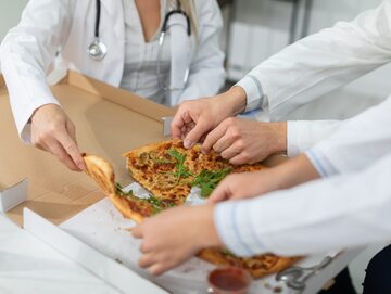 Lekarze jedzący pizzę. Zdjęcie ilustracyjne