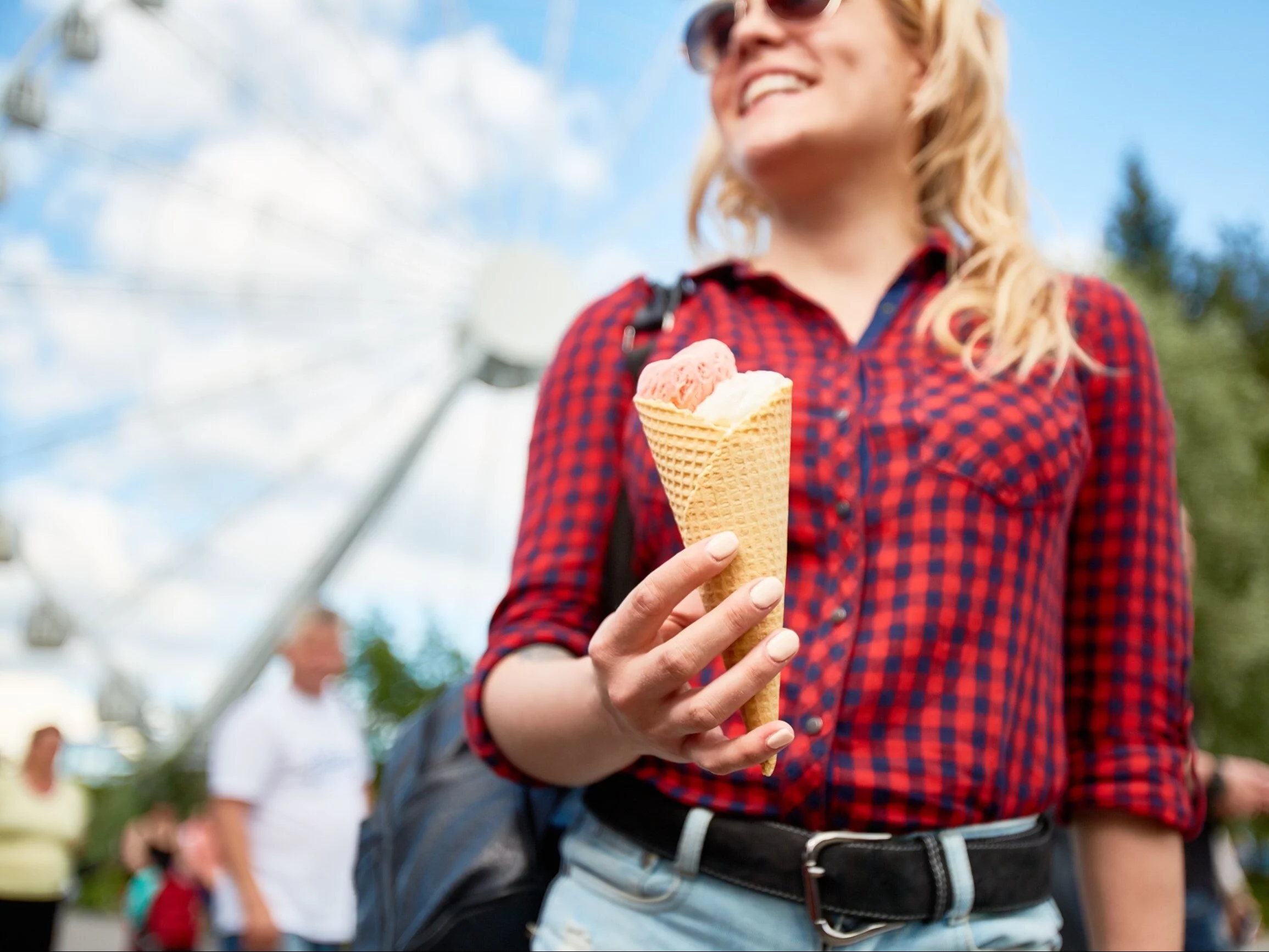 Kobieta jedząca lody w wesołym miasteczku