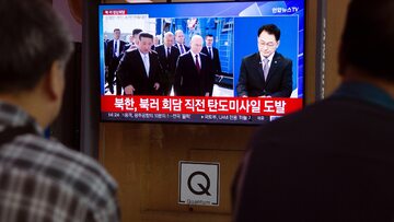 Ludzie oglądający telewizyjny program informacyjny relacjonujący spotkanie Kim Dzong Una z Władimirem Putinem, stacja kolejowa w Seulu