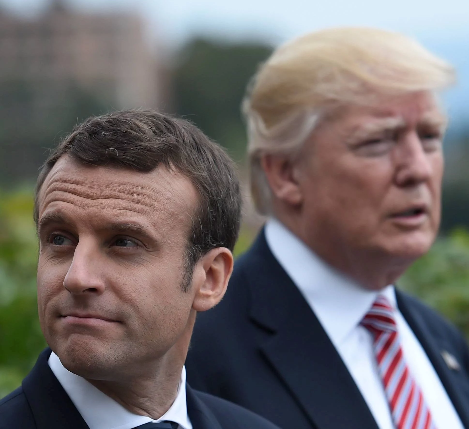 Emmanuel Macron, w tle Donald Trump