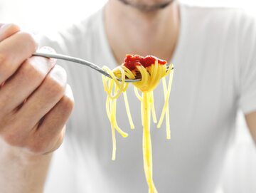 Mężczyzna je spaghetti
